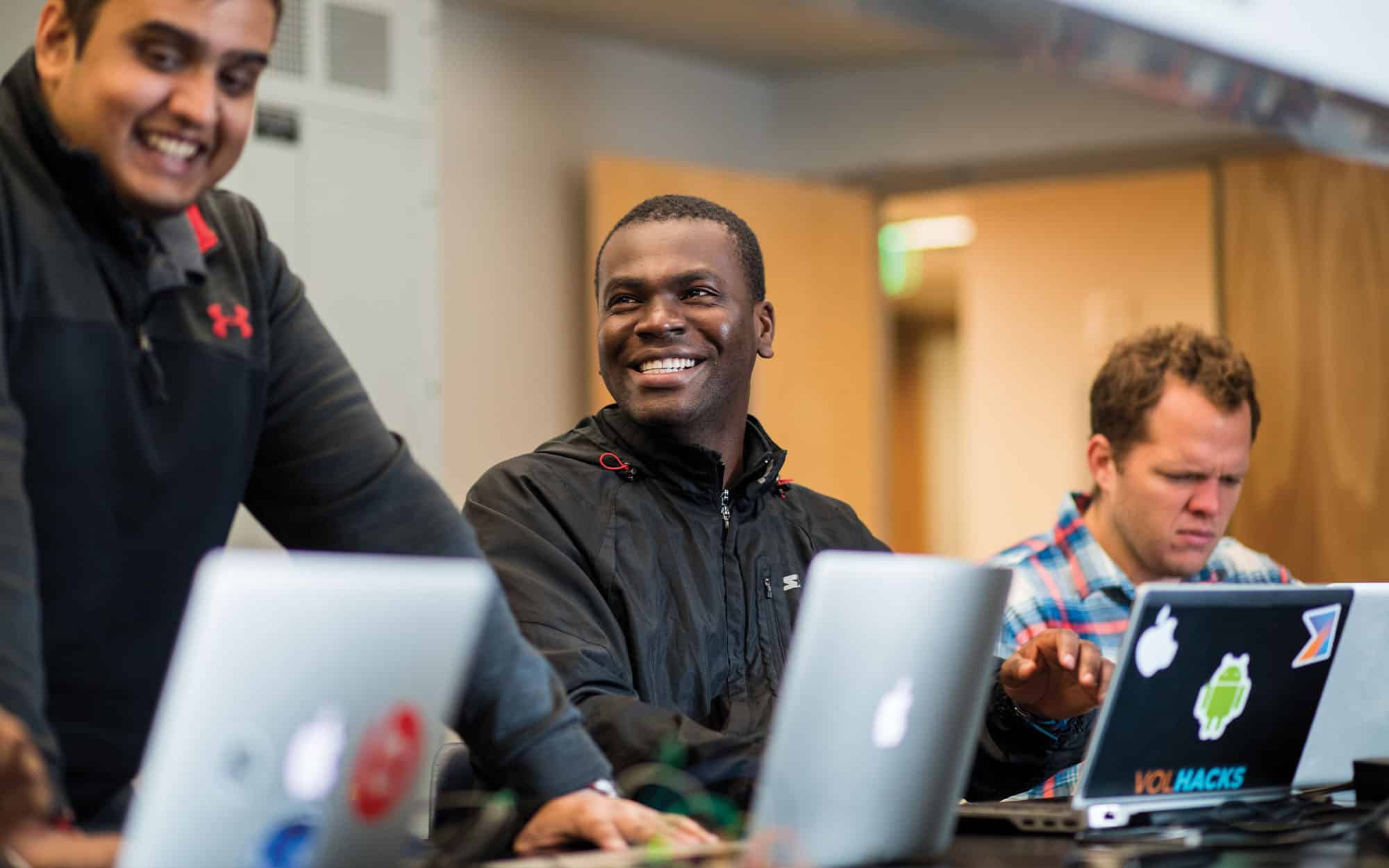 Three EECS students work on a laptops inside a Min Kao Engineering Building Lab.