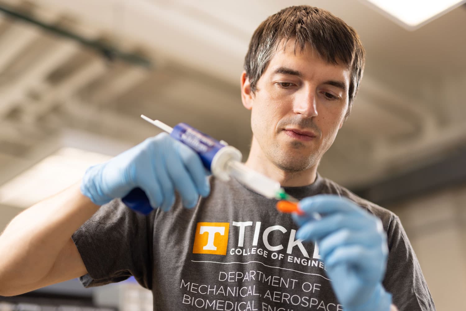 Dustin L. Crouch, Assistant Professor, covers a 3d printed part with silicone while make prosthetic feet for rabbits in the Upper Limb Assist Lab inside the Dougherty Engineering Building