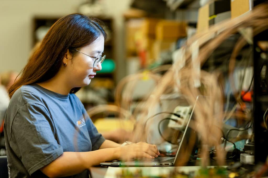 Student works on computer inside a Min H. Kao Electrical Engineering and Computer Science Building Lab.