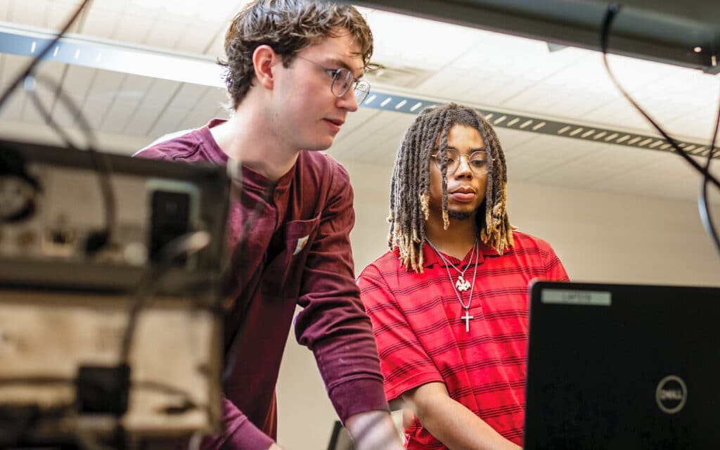 Two students work on computers inside a Min H Kao Engineering Building lab.