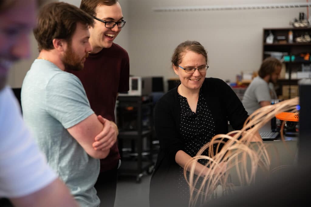 Assistant Professor Catherine Schuman speaks to graduate students in a neuromorphic computing lab in the Min H. Kao Electrical Engineering and Computer Science Building.