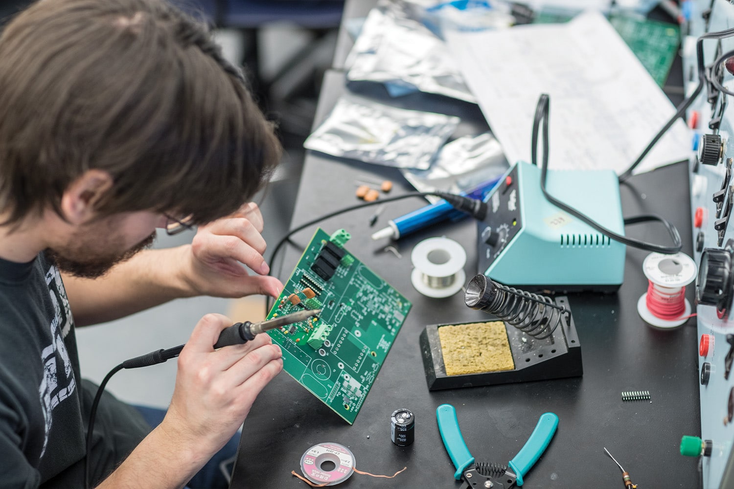 Student works with circuit board inside the Power Lab in the Min H. Kao Electrical Engineering and Computer Science Building.