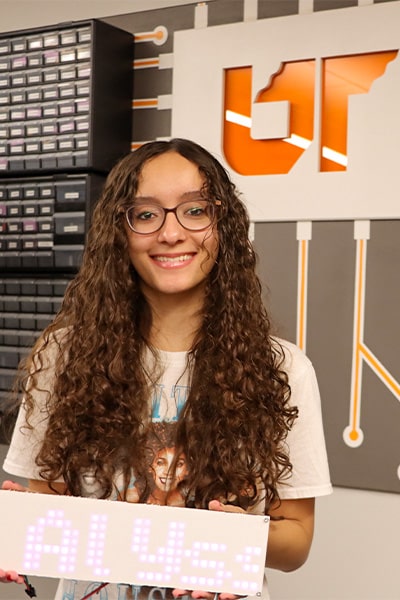 Alyssa Bice holding a digital sign in a computer room