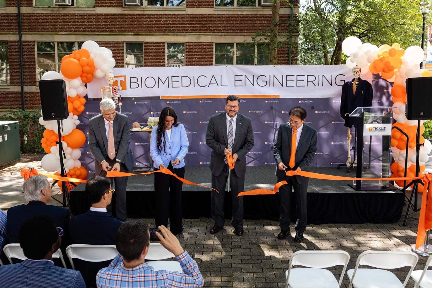 Faculty and students cut the ribbon during the ribbon cutting ceremony.