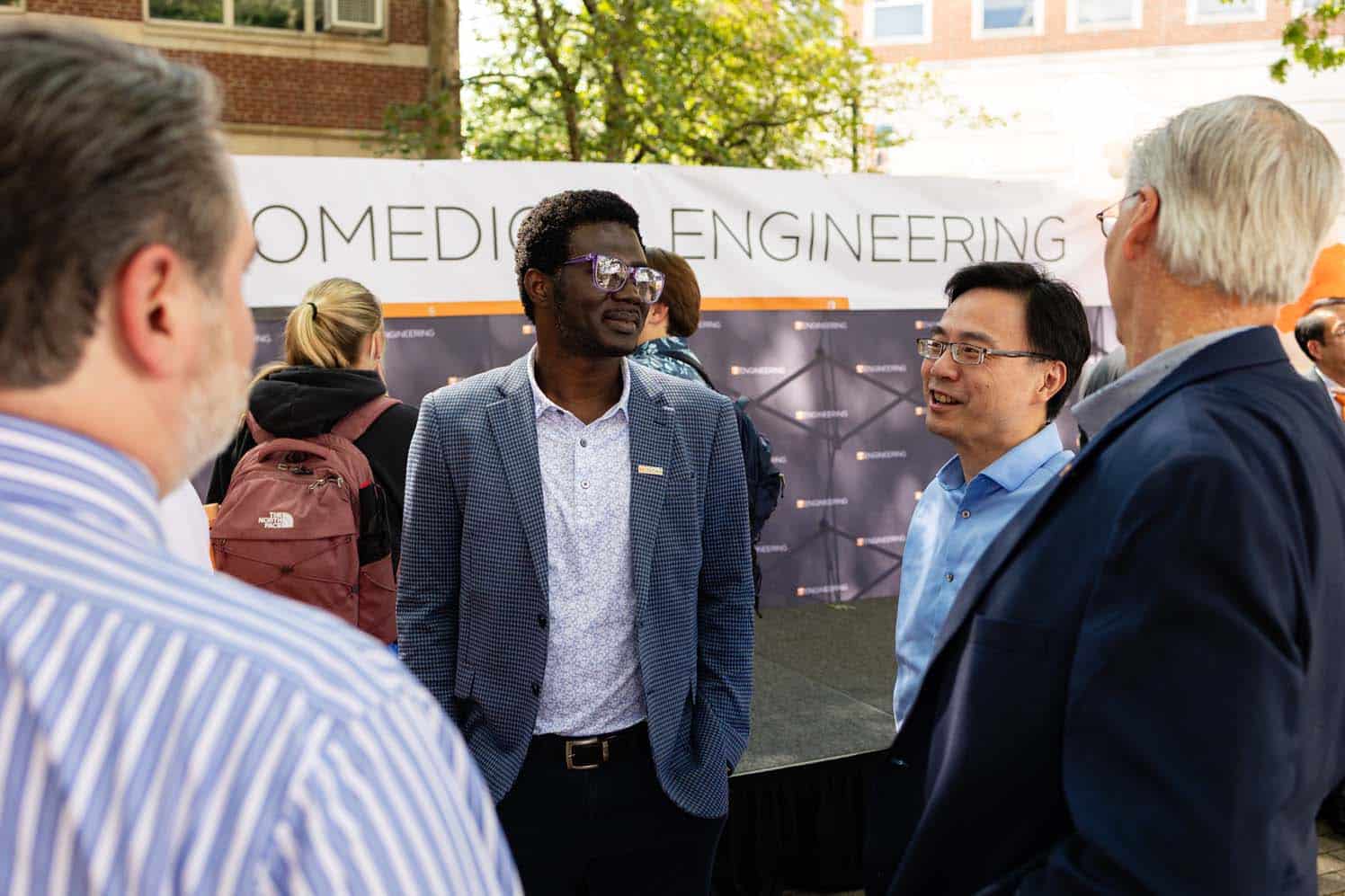 Michael Danquah speaks with department heads after the ceremony.