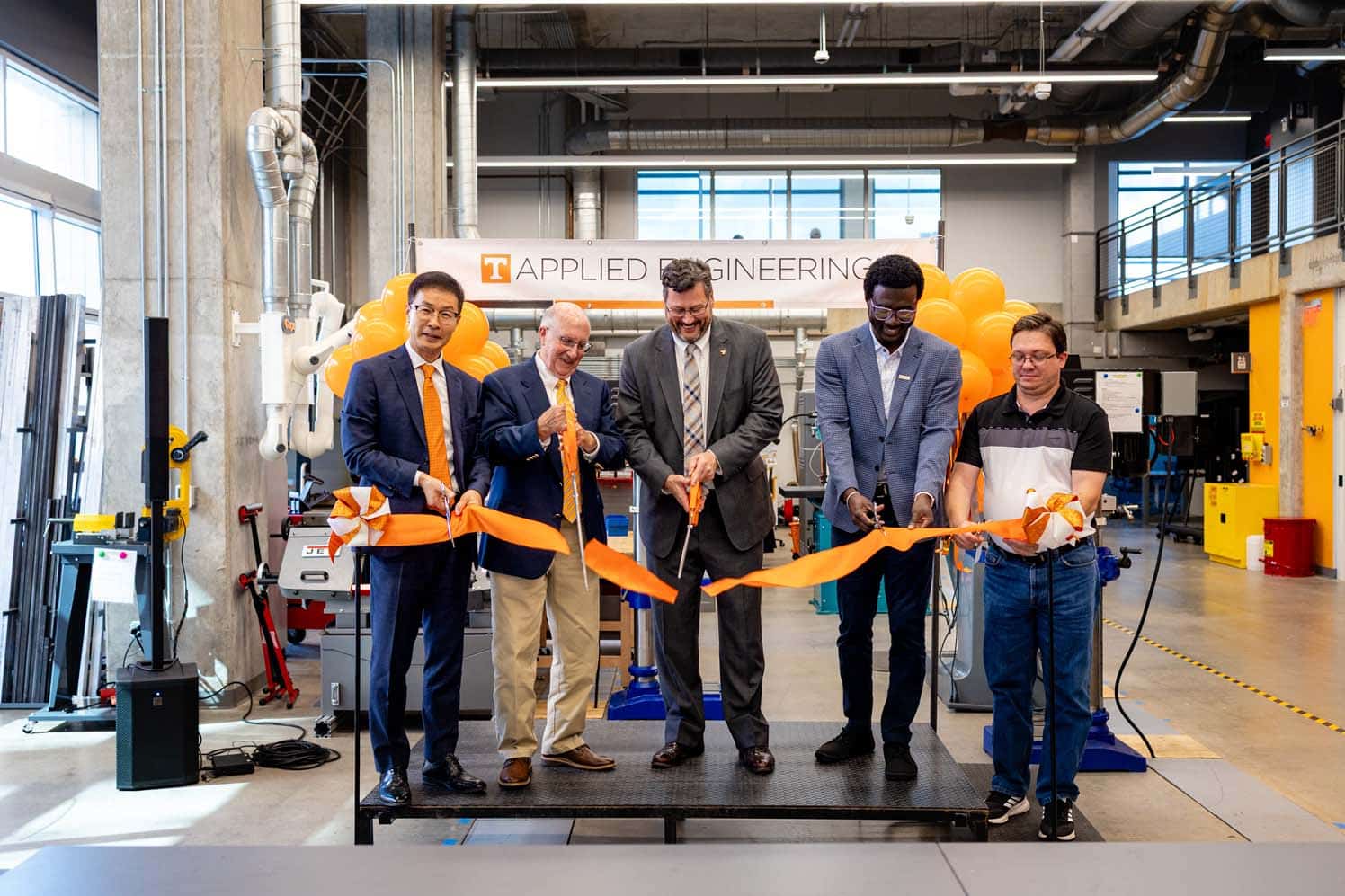 Faculty and alumni of the college cut the ribbon during the ceremony.