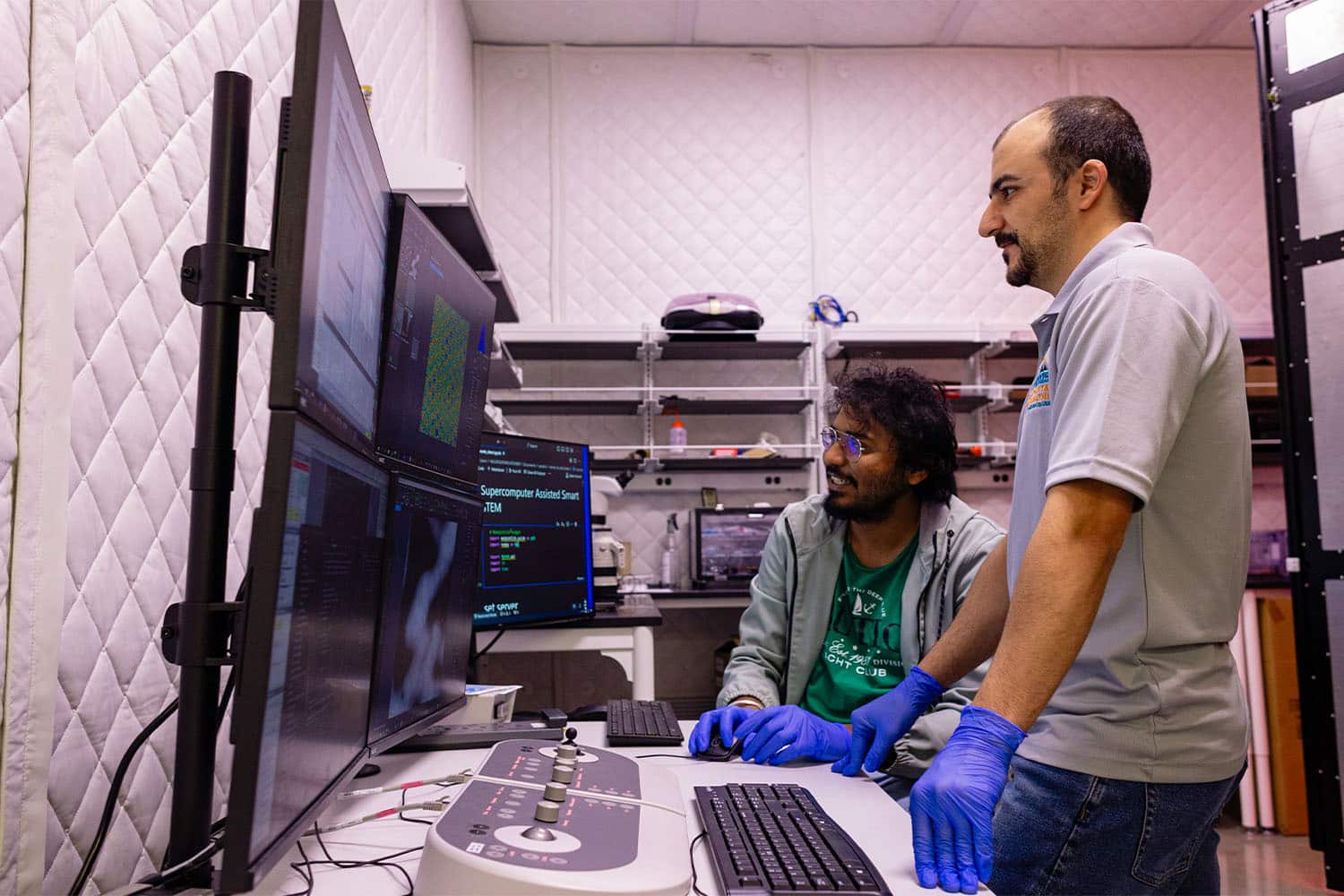 Two UT researchers review images from the electron microscope.