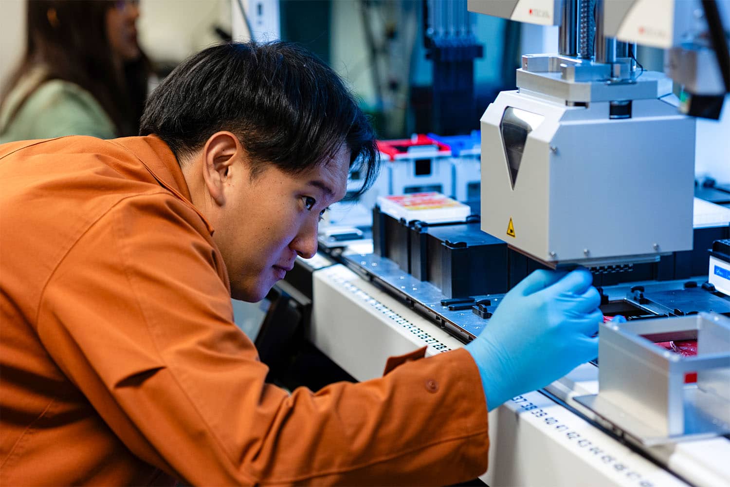 UT student researcher works with a liquid handling robot creating samples in one of UT's materials synthesis labs. 