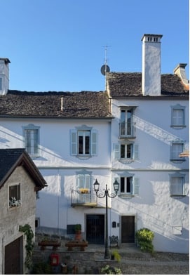 Exterior of a white building on a cobblestone alley