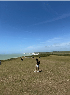 Andrew Kim walking alongside a large cliff overlooking the ocean