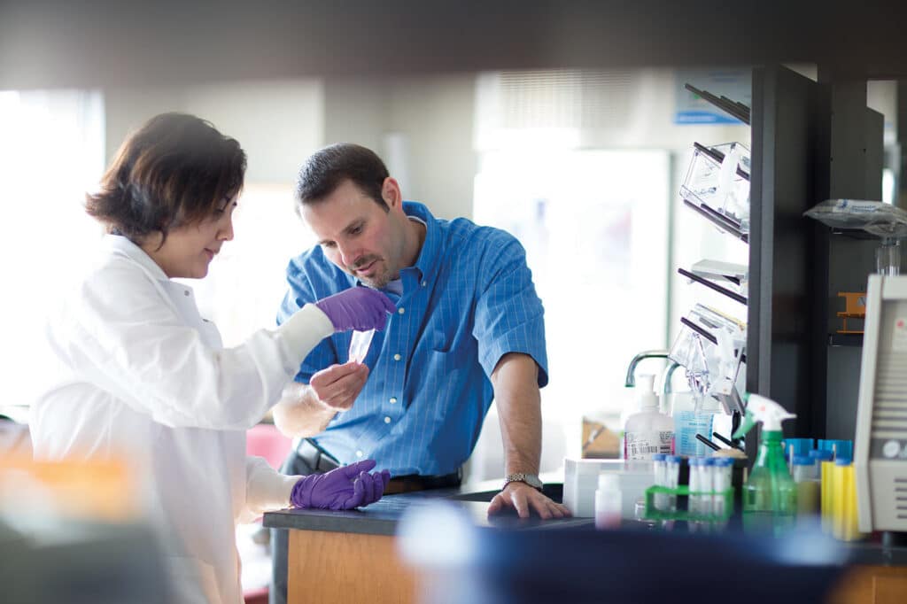 Eric Boder works with graduate student in a lab