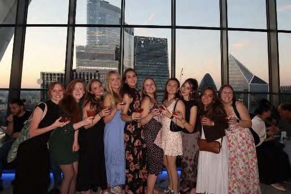 Sarah Howard posing with fellow female classmates while each holds a glass beverage
