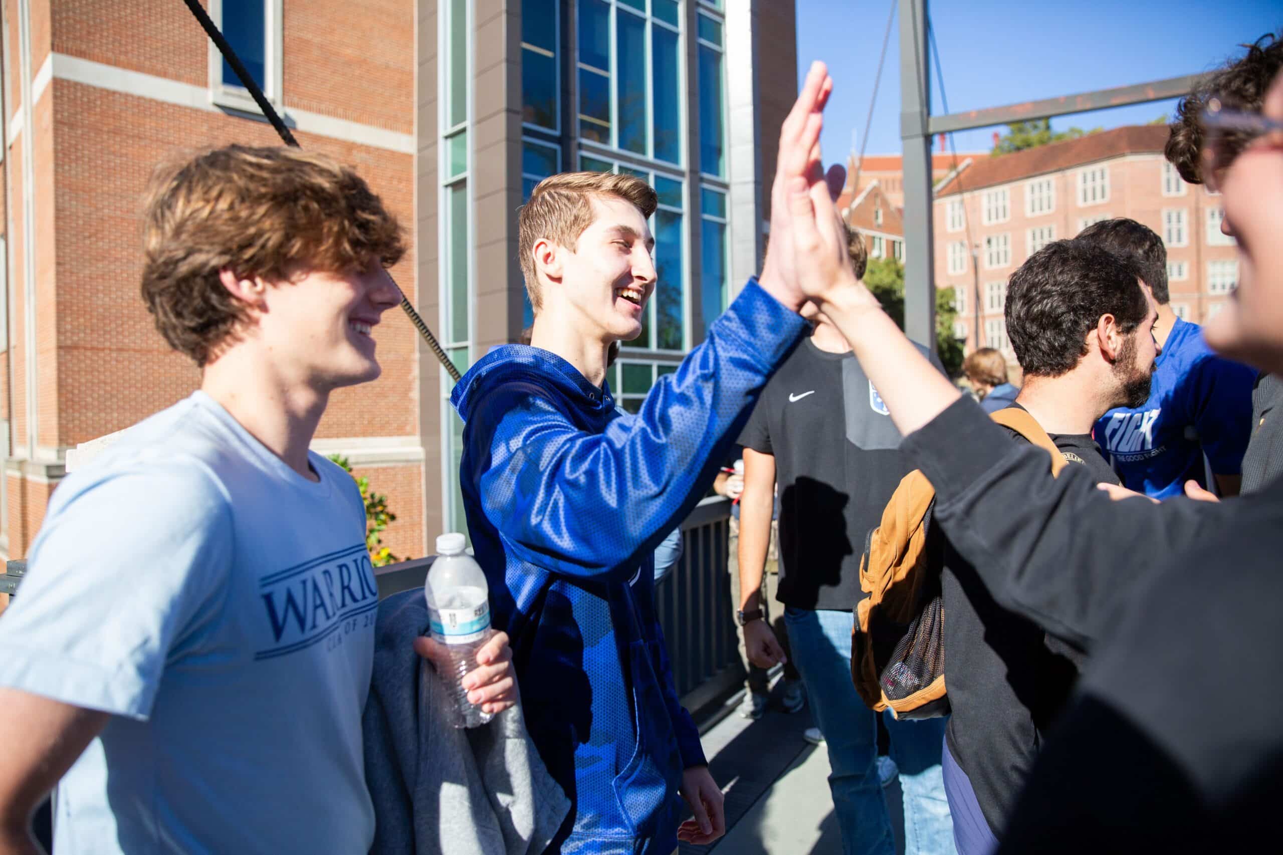 High school students high fiving outside the Zeanah Engineering Complex
