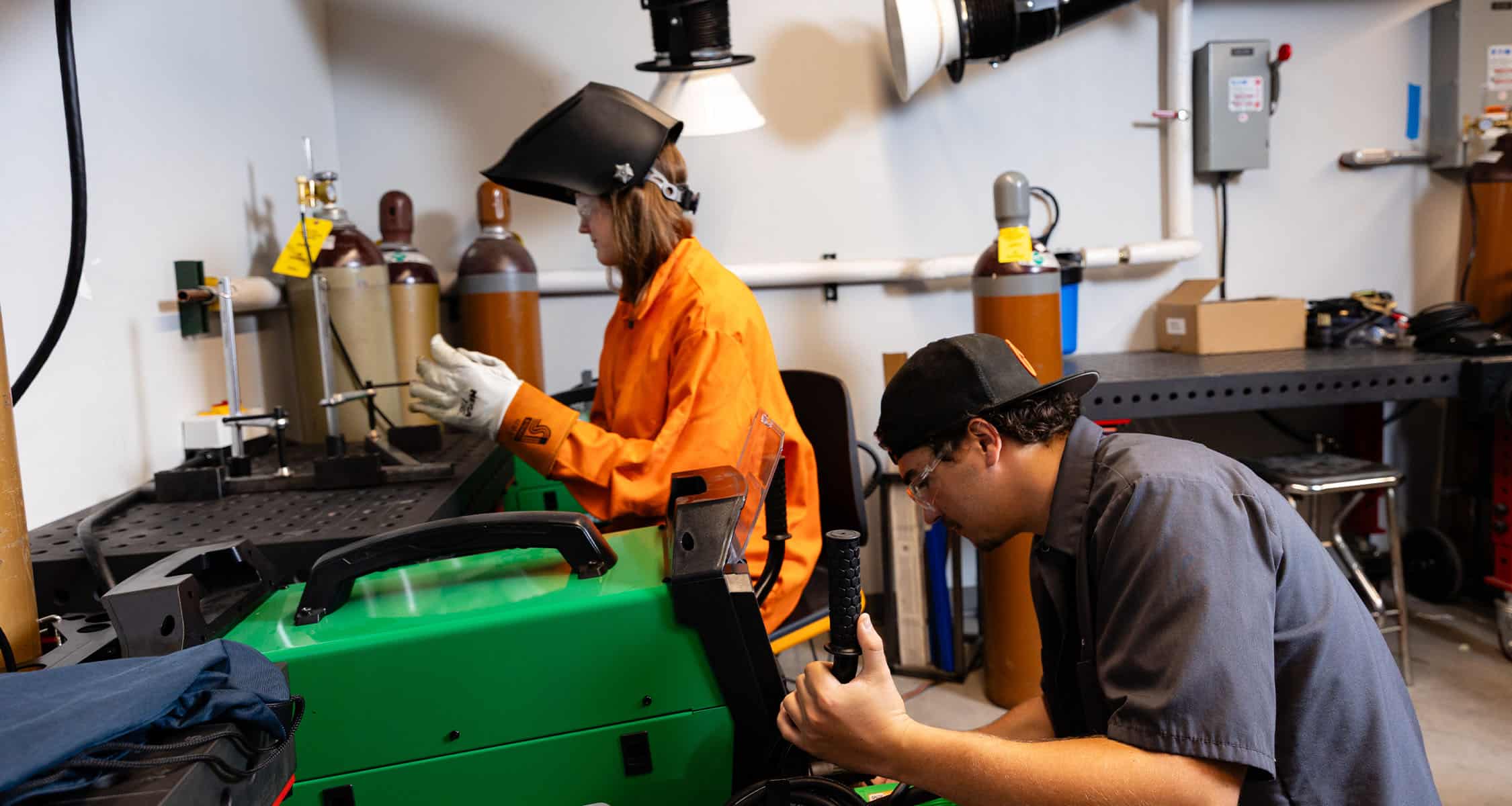 Two students set up the welding station inside the ICS
